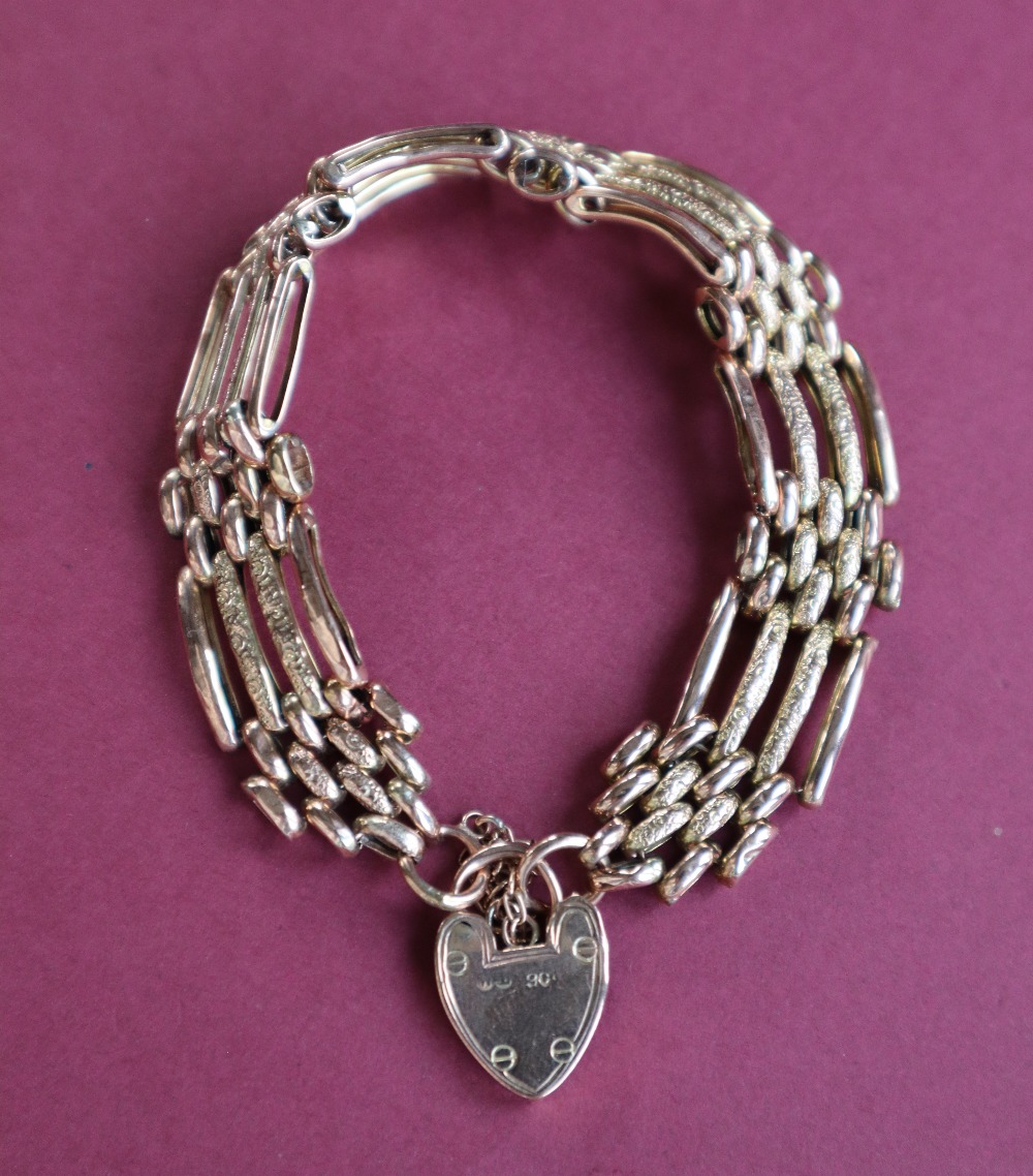 A 9ct gold gate bracelet, set with four bars to a padlock clasp, approximately 16.