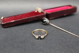A sapphire and diamond ring set with a central round faceted sapphire flanked by a pair of round