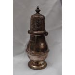 A George V silver sugar caster with a pierced domed cover and ring turned baluster body on a