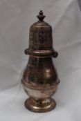 A George V silver sugar caster with a pierced domed cover and ring turned baluster body on a