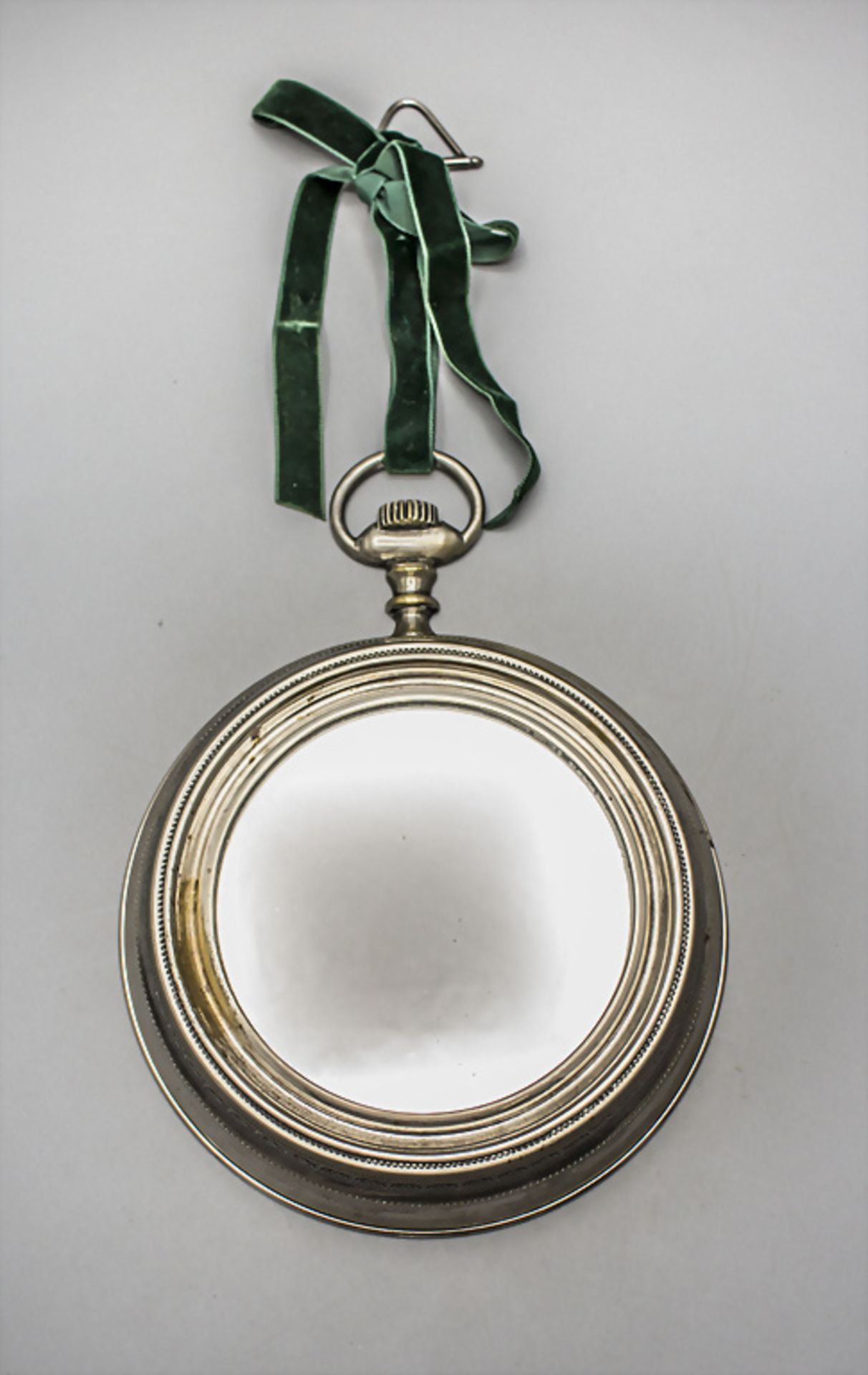 Wandspiegel in Form einer Taschenuhr / A wall mirror in the shape of a pocketwatch, ...