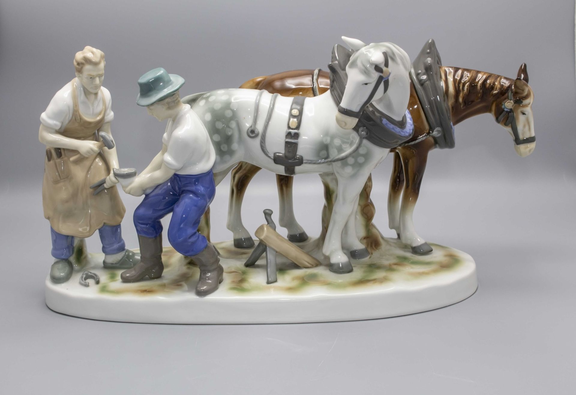 Figurengruppe eines Hufschmieds mit Pferden / A porcelain group of a farrier with horses, ...