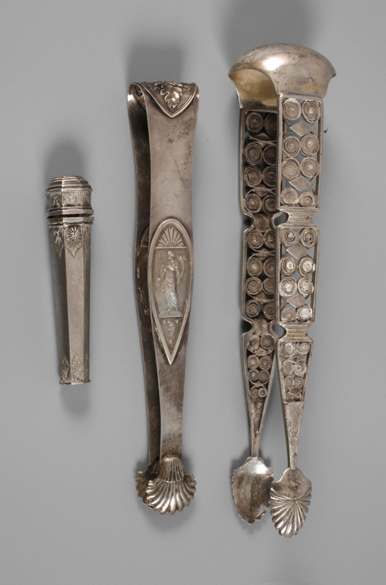Two sugar tongs and a needle case