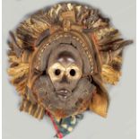 Afrikanische Maske mit Federschmuck.