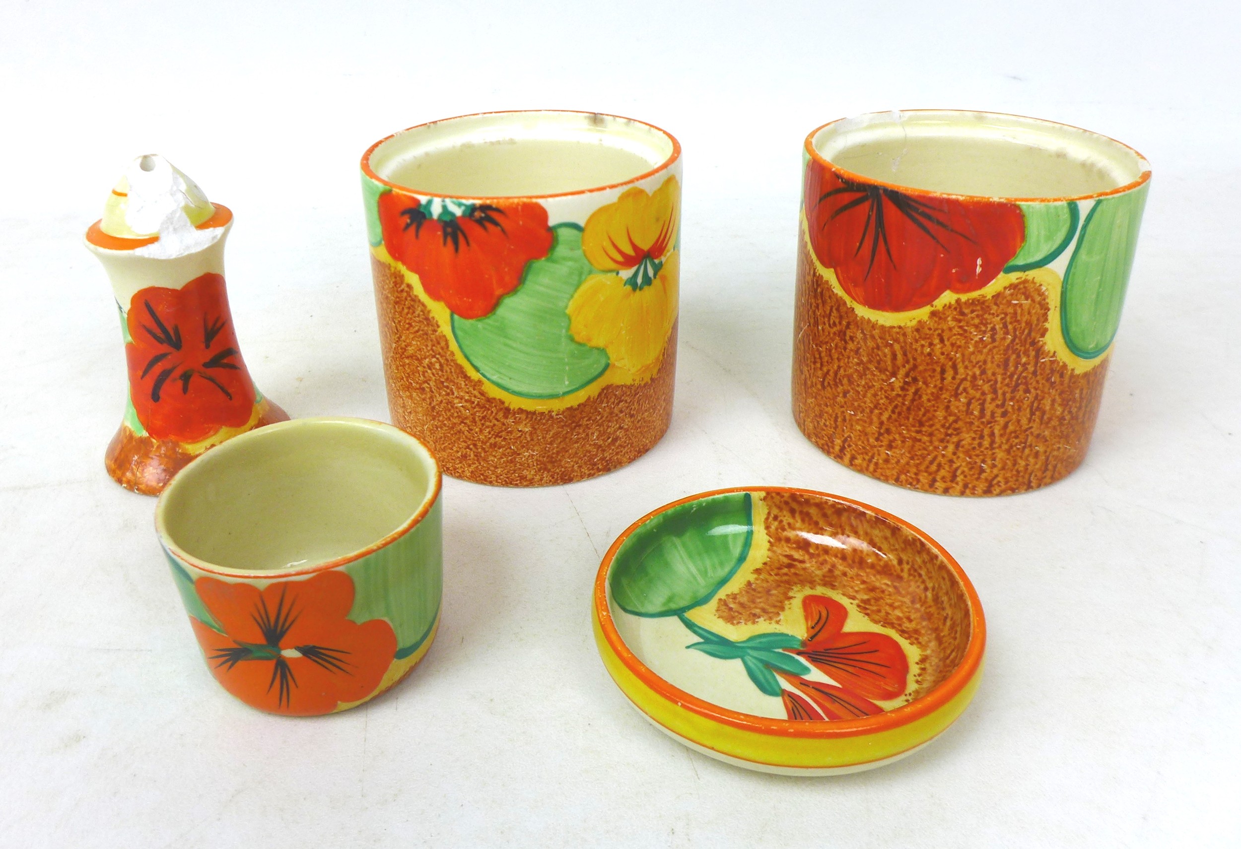 A collection of Clarice Cliff 'Nasturtium' pieces, comprising two drum shaped preserve pots, without