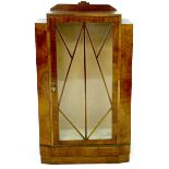 An Art Deco walnut veneered display cabinet, single geometric astragal glazed door, two glass