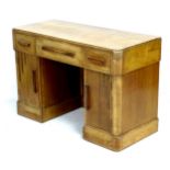 An Art Deco oak desk / dressing table, with three drawers over two cupboards to the twin