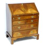 A reproduction George III style walnut veneered bureau, fitted interior, raised on bracket feet,