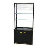 A vintage Pierre Vandel display cabinet, with black and gold finish over a square section tubular