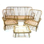 A group of dark Ercol furniture, comprising a three seater settee and two armchairs, a foot stool,
