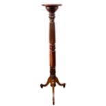 An Edwardian mahogany jardiniere stand, with dished circular surface, raised on a reeded and foliate