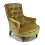 A Victorian armchair, upholstered in light brown buttoned velvet, with turned front legs and brass