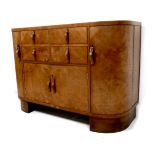 An Art Deco walnut veneered sideboard, with an arrangement of four drawers over twin cupboards,