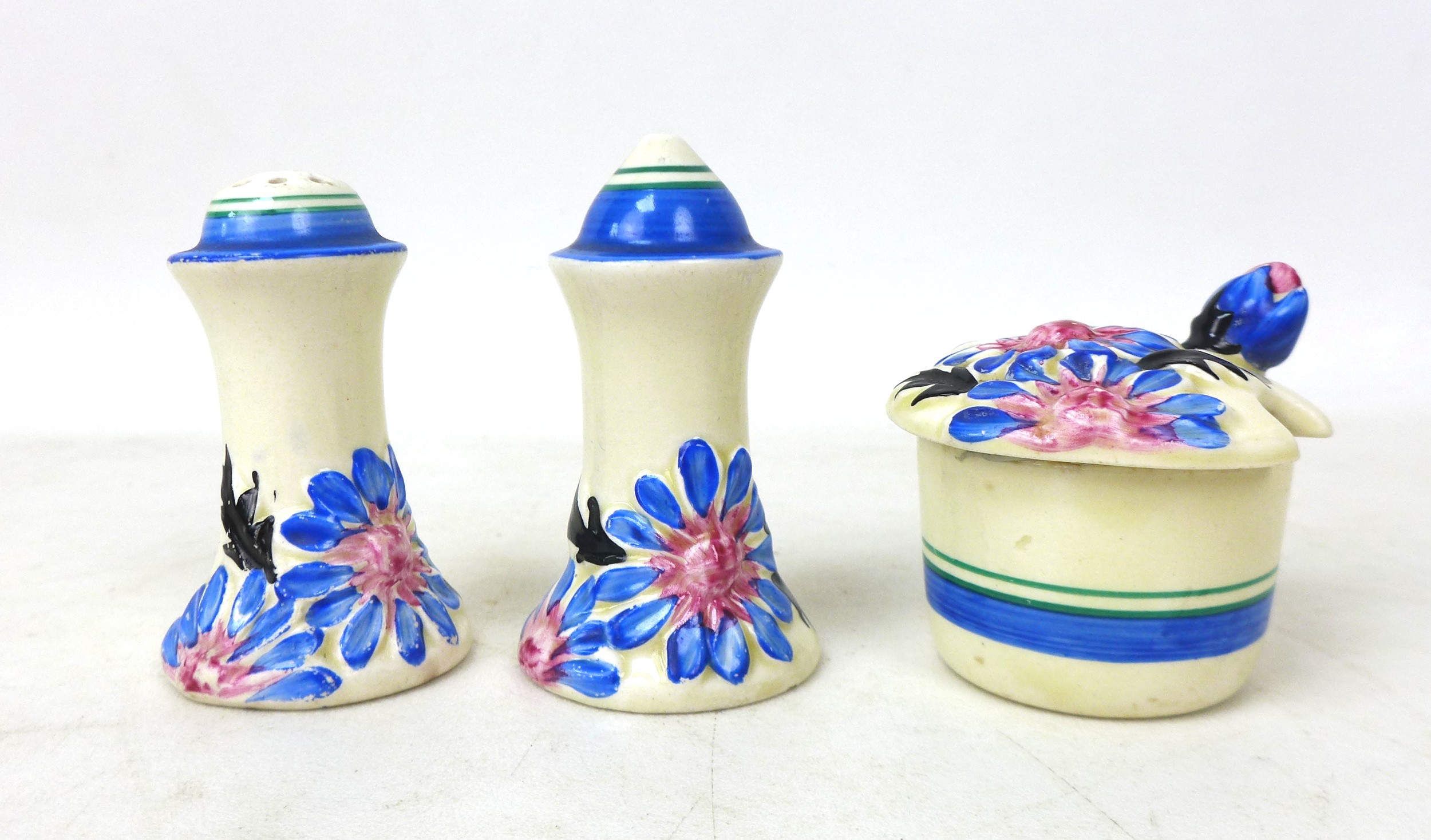 A Clarice Cliff 'Marguerite' Muffineer cruet set, relief moulded with flowers and foliage picked out