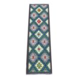A Maimana Kilim runner, with diamond patterned of blue, purple, green, and cream, encased in a brown