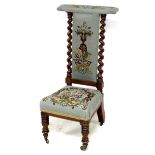 A Victorian tapestry covered prie dieu chair, with spiral columns framing the back, raised on
