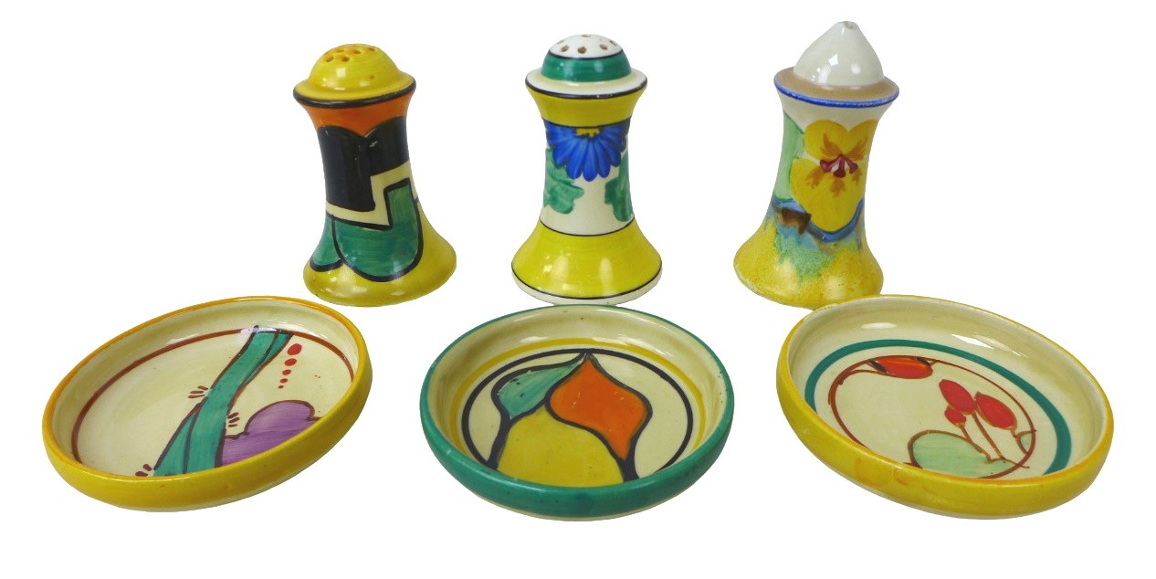 A mixed group of Clarice Cliff, including a 'Castellated Circle' and 'Sungay' Muffineer pepper pots,