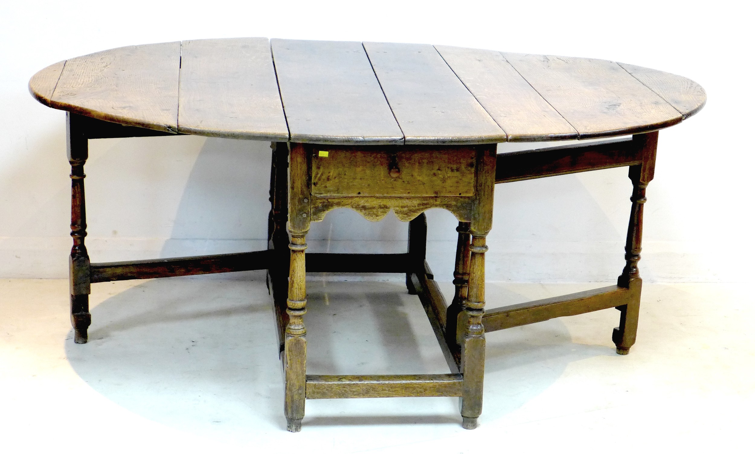 A 17th or 18th century oak drop leaf dining table, with oval surface, twin gate leg action, raised - Image 2 of 5