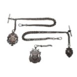An Edwardian silver double Albert chain, attached with two T-bars and three fobs, one fob