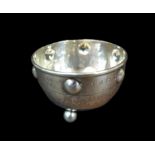 A George V Arts & Crafts silver sugar bowl, of circular form with planished main body raised upon