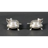 A pair of silver lidded mustard pots, of cauldron form with scroll handle and attached thumb pieces,