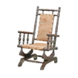 An early 20th century child's American rocker, with mahogany frame with turned supports, upholstered