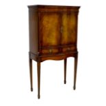 A late 20th century cocktail cabinet, in George III style, with serpentine front, walnut veneers,