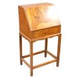 An Art Deco walnut veneered student's desk, with fall front enclosing writing skivver and fitted