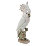 A Royal Dux porcelain figurine, modelled as a cockatoo standing on a branch, with pink plumage, with