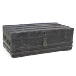 A late Victorian or Edwardian trunk, the wooden carcass bound in dark metal and wooden batons,