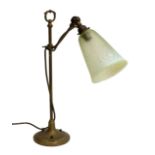 An Art Nouveau brass table lamp, with pale green glass shade, 12cm at opening, 50cm high.