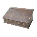 An 18th century oak Bible box, with carved front panel and interior cubby holes, 57.5 by 37.5 by