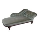 An Edwardian chaise longue, with walnut frame and button backed green upholstery, raised upon