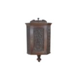 A small oak corner cupboard, with carved foliate and floral decoration, 32 by 33 by 85.5cm high.