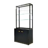 A vintage Pierre Vandel display cabinet, with black and gold finish over a square section tubular