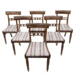 A set of six Georgian style dining chairs, with drop in upholstered seats, reeded forelegs, sabre