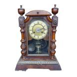 A Edwardian stained wood mantel alarm clock, cream dial with Roman numerals, with pendulum and key.