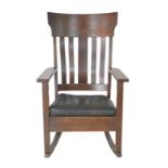 An Arts & Crafts style beechwood rocking chair, with slat back, open armrests above square section