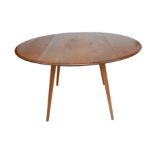 An Ercol circular elm and beech drop leaf dining table, circa 1970, No 384, 'Dining Table', 123 by