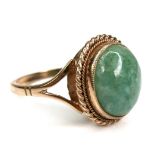 A 9ct yellow gold and jade set ring, the oval cabochon cut jade 11.8 by 9.8mm, in rub over setting