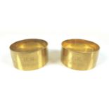 A pair of George V 9ct gold napkin rings, one engraved 'J.H. 1873-1923' the other 'M.H. 1873-