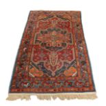 A Persian rug, on red ground, with large blue and orange central medallion with pendant anchors,