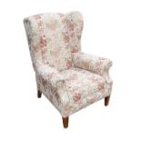 An Edwardian wingback armchair, with embroidered red, green, and cream upholstery, 77 by 83 by 103cm
