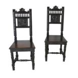 A pair of 19th century oak hall chairs, with shaped top rails and carved back panels, solid seats