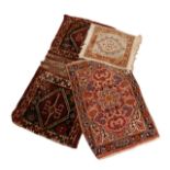 A group of three Persian rugs, including a hand knotted camel saddle bag, 125 by 64cm, a Persian