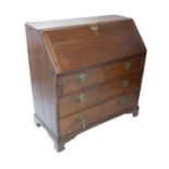 A Georgian oak bureau, with fall front revealing fitted interior, over three long drawers with brass