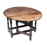 A late 18th century oak drop leaf table, with oval top, two gate legs with turned supports, fully