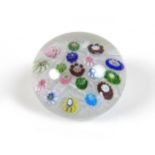 A Clichy paperweight, mid 19th century, with multicoloured roses amongst white cane work, 5.5cm