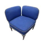 An unusual Victorian corner armchair, upholstered in blue cotton, raised on turned legs.