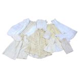 A large collection of Victorian baby and large doll gowns, dresses and coach capes, many with hand